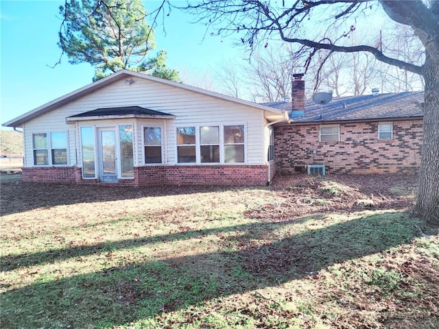 rear view of house featuring a yard