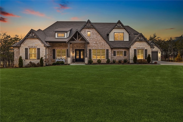 view of front of property with concrete driveway, a front lawn, roof with shingles, and french doors