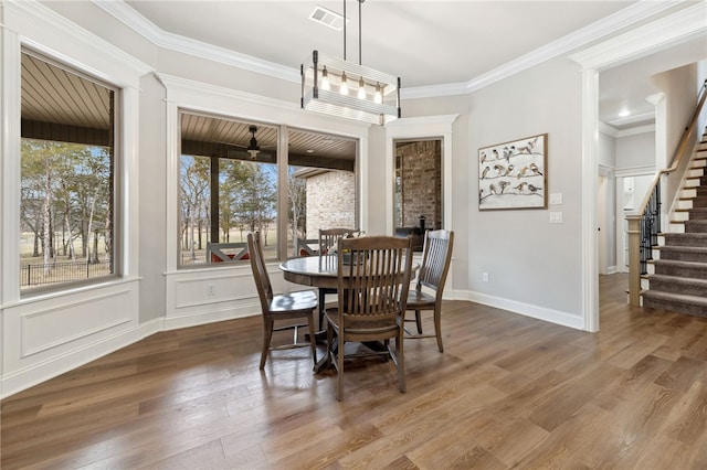 dining space with crown molding and wood-type flooring