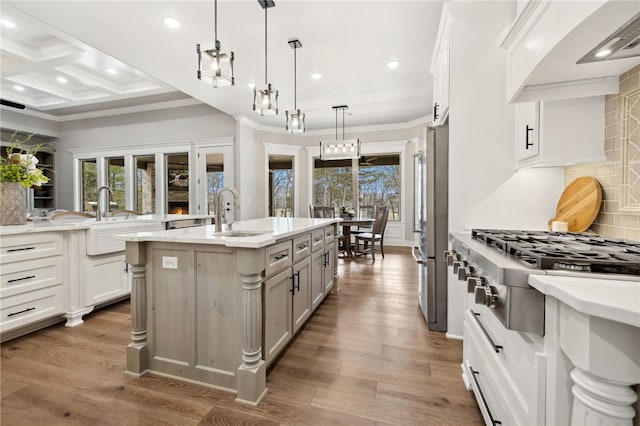 kitchen featuring sink, white cabinetry, a center island with sink, appliances with stainless steel finishes, and pendant lighting