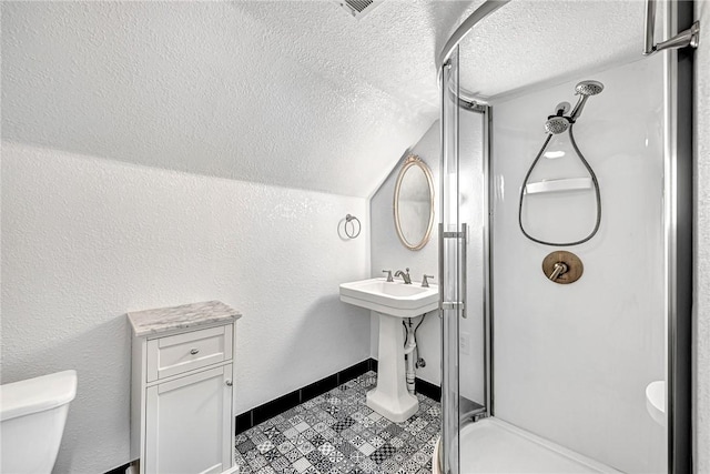 bathroom featuring toilet, lofted ceiling, a textured ceiling, and walk in shower