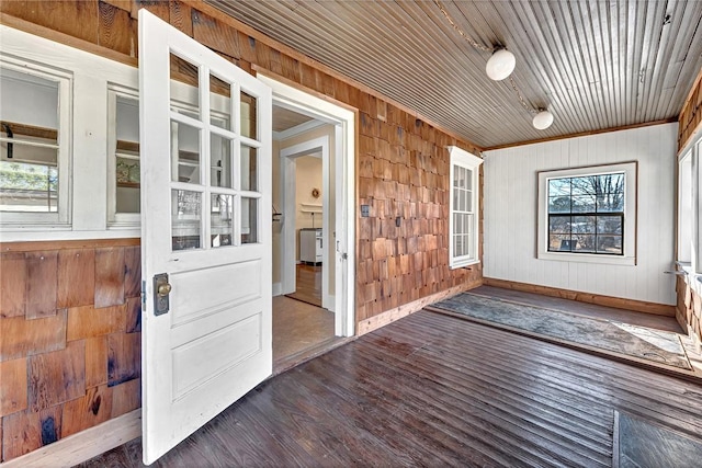 foyer entrance with dark wood-type flooring and wood walls