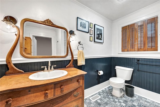 bathroom featuring vanity, tile patterned flooring, crown molding, and toilet