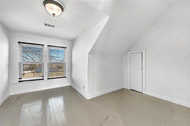 bonus room with lofted ceiling and hardwood / wood-style floors