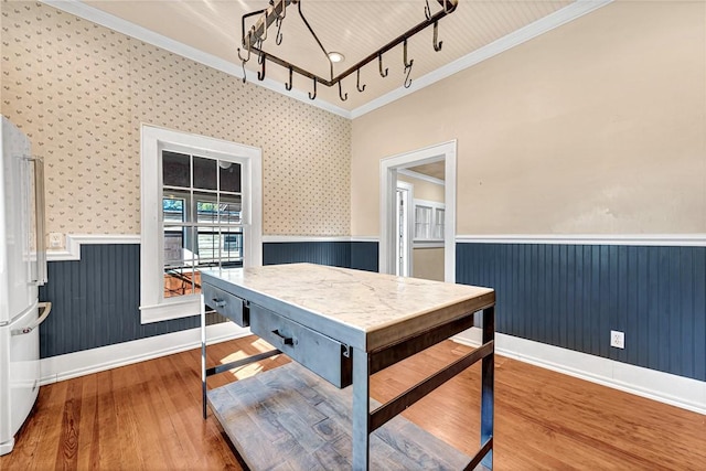 dining area featuring track lighting, ornamental molding, and hardwood / wood-style floors