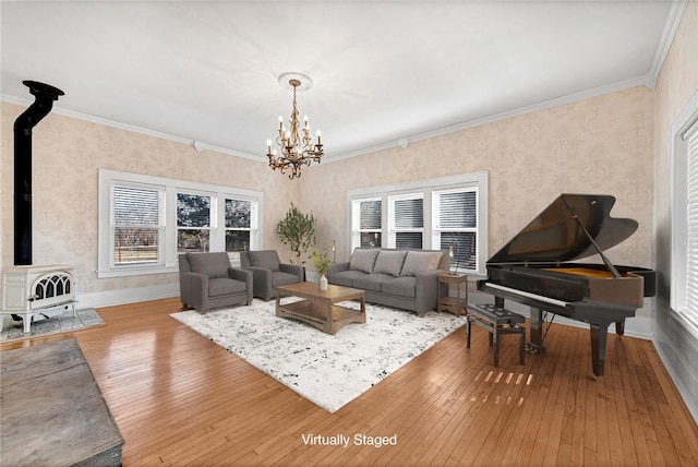 living room with ornamental molding, wood-type flooring, a notable chandelier, and a wood stove