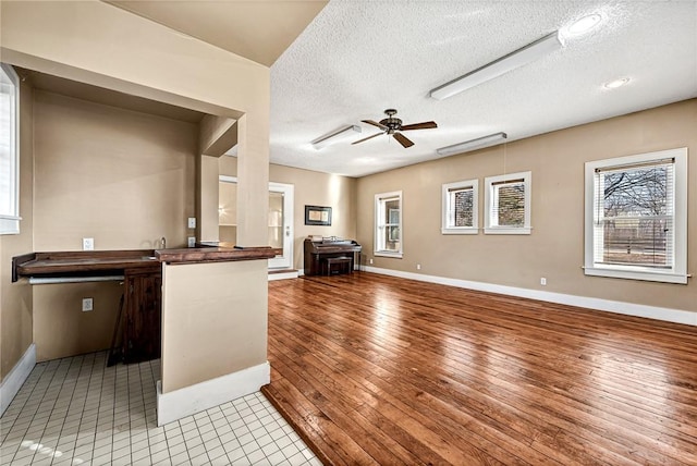 kitchen with a textured ceiling, light hardwood / wood-style flooring, and ceiling fan