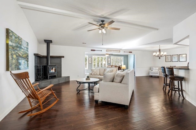 living room with vaulted ceiling with beams, ceiling fan, dark hardwood / wood-style flooring, and a wood stove