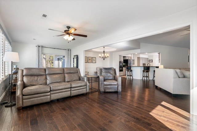 living room featuring ornamental molding, dark hardwood / wood-style flooring, and ceiling fan with notable chandelier