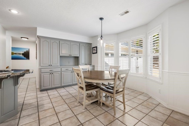 dining area with light tile patterned flooring and a textured ceiling