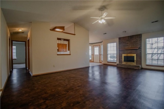 unfurnished living room featuring vaulted ceiling, a brick fireplace, dark wood-type flooring, and ceiling fan