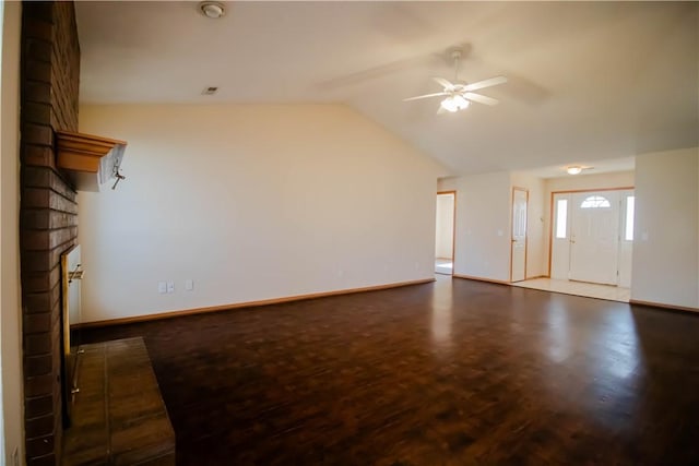 unfurnished living room featuring vaulted ceiling, a brick fireplace, hardwood / wood-style floors, and ceiling fan