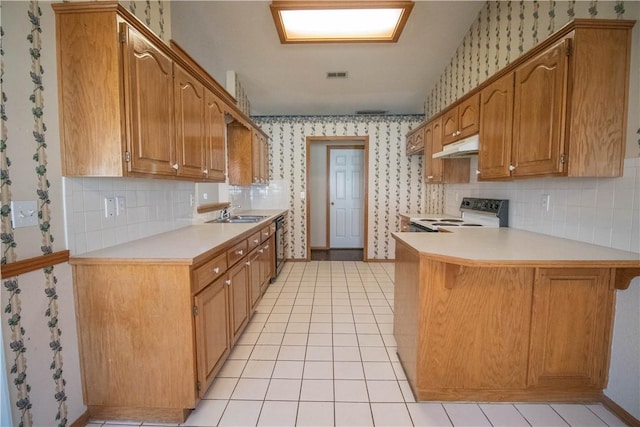 kitchen with dishwasher, kitchen peninsula, light tile patterned floors, and electric stove