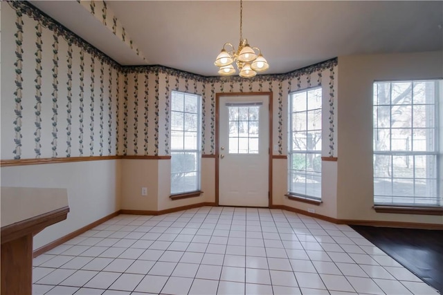 doorway to outside featuring a notable chandelier and light tile patterned flooring