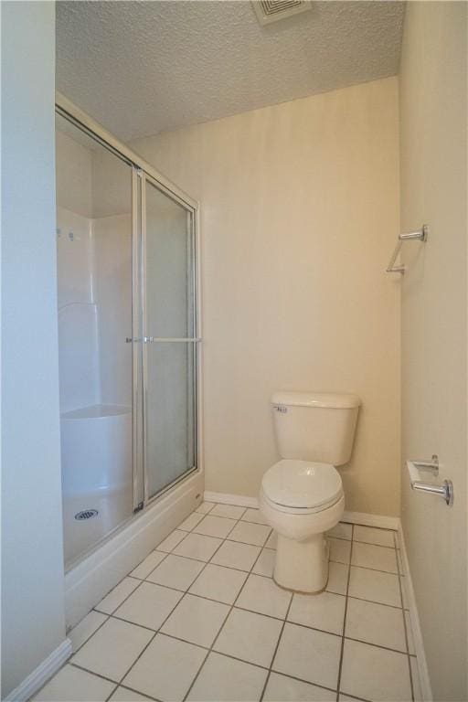 bathroom with an enclosed shower, tile patterned floors, a textured ceiling, and toilet