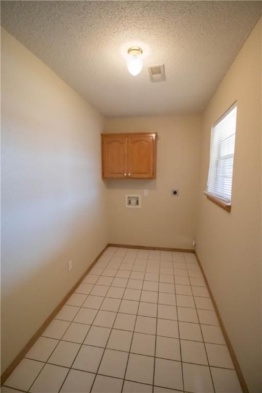 laundry area featuring cabinets, washer hookup, hookup for an electric dryer, and a textured ceiling