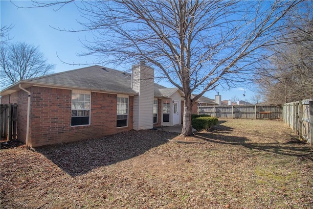 rear view of house featuring a yard