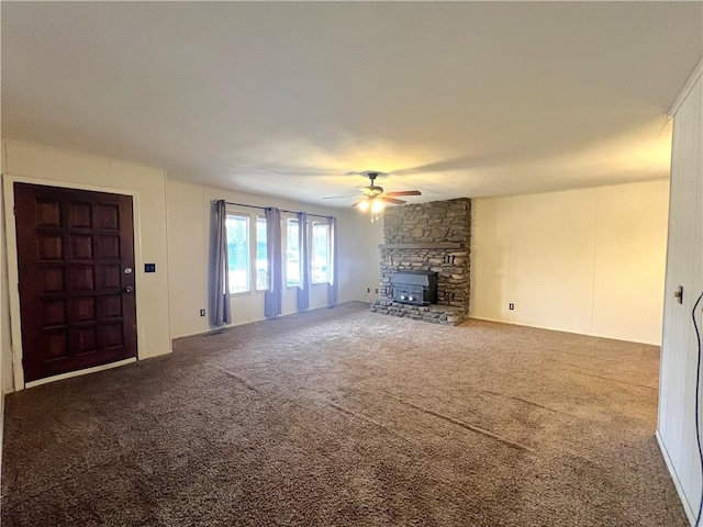 unfurnished living room with a fireplace, ceiling fan, and carpet flooring