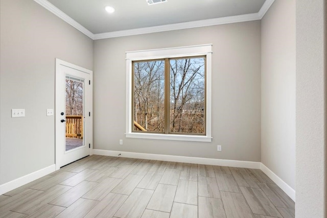 empty room featuring baseboards, visible vents, wood finish floors, and crown molding