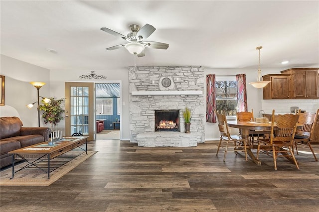 dining room with ceiling fan, dark hardwood / wood-style floors, and a fireplace