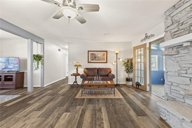 living room featuring dark wood-type flooring and ceiling fan