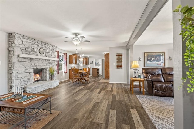 living room with ceiling fan, a fireplace, and dark hardwood / wood-style floors