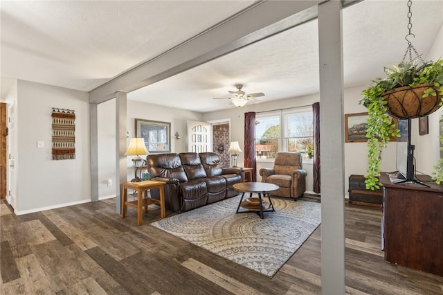 living room with beamed ceiling, dark hardwood / wood-style floors, and ceiling fan