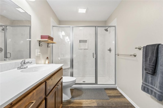 bathroom featuring walk in shower, vanity, toilet, and hardwood / wood-style flooring