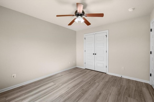 unfurnished bedroom with light hardwood / wood-style floors, a closet, and ceiling fan