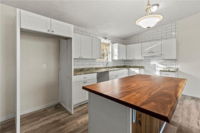 kitchen with white cabinetry, hardwood / wood-style floors, and decorative backsplash