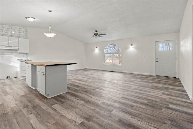 kitchen with white cabinetry, pendant lighting, wood counters, and light hardwood / wood-style floors