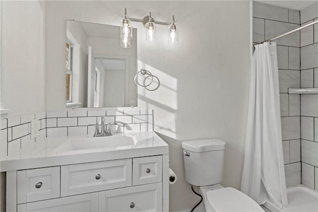 bathroom with vanity, backsplash, and toilet