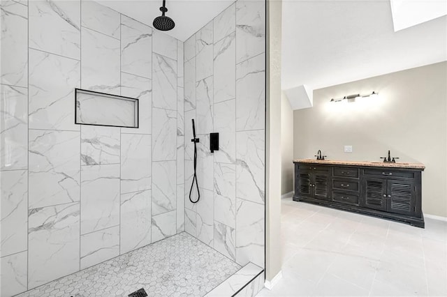 bathroom featuring tiled shower and vanity