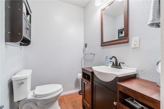 bathroom with vanity, toilet, and hardwood / wood-style floors