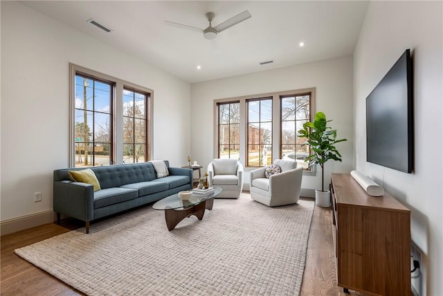 living room featuring wood-type flooring and ceiling fan