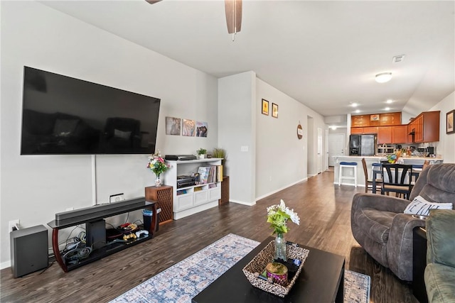 living room featuring dark wood-type flooring and ceiling fan