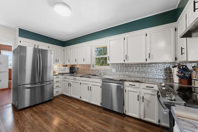 kitchen featuring stainless steel appliances, white cabinetry, dark wood-type flooring, and decorative backsplash