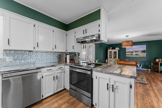 kitchen with appliances with stainless steel finishes, decorative light fixtures, kitchen peninsula, and white cabinets