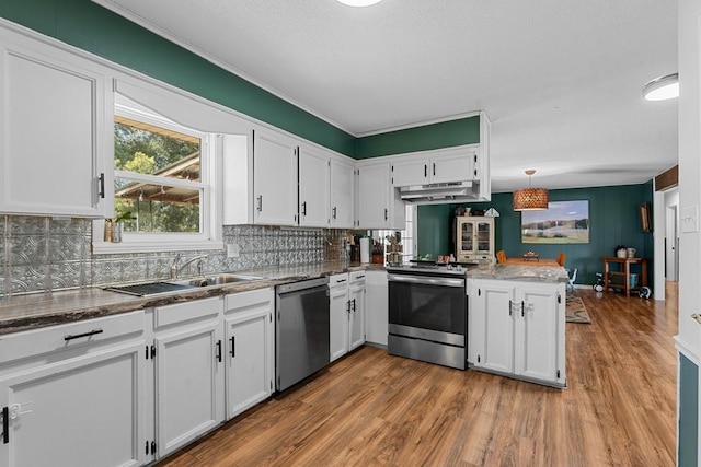 kitchen with pendant lighting, hardwood / wood-style floors, stainless steel appliances, white cabinets, and kitchen peninsula