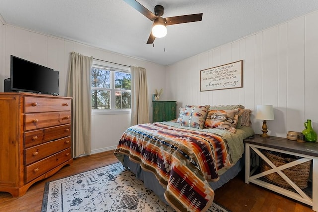 bedroom with ceiling fan, a textured ceiling, and light wood-type flooring