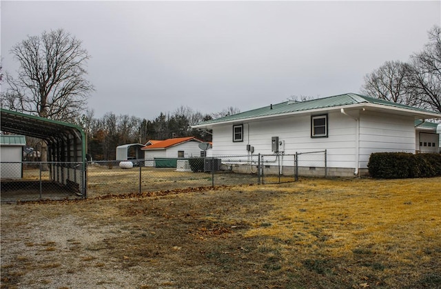 back of property featuring a carport, central AC unit, and a lawn