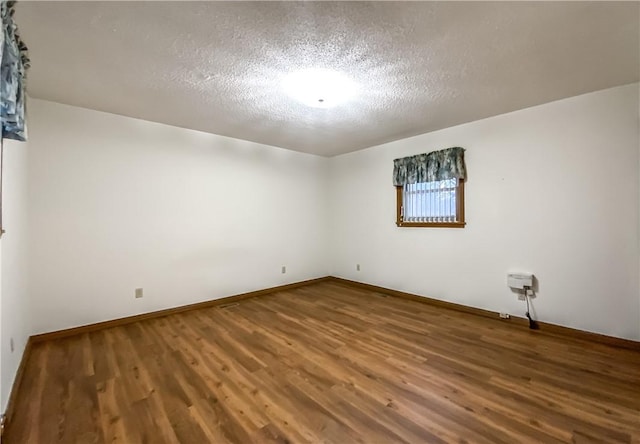 spare room with wood-type flooring and a textured ceiling