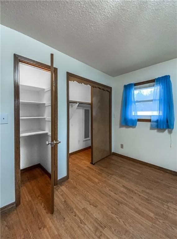 unfurnished bedroom with hardwood / wood-style flooring and a textured ceiling