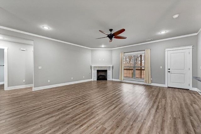 unfurnished living room featuring hardwood / wood-style flooring, ceiling fan, and crown molding