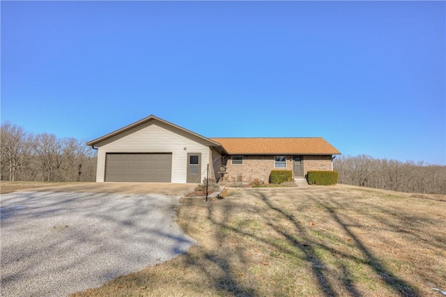 ranch-style home featuring a garage and a front lawn