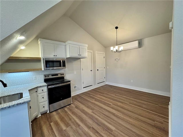 kitchen with sink, appliances with stainless steel finishes, white cabinetry, a wall mounted air conditioner, and light stone countertops