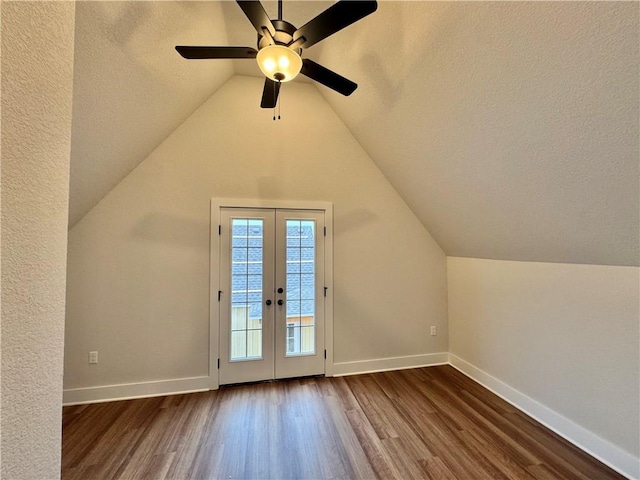 bonus room with dark wood-type flooring, vaulted ceiling, french doors, and a textured ceiling