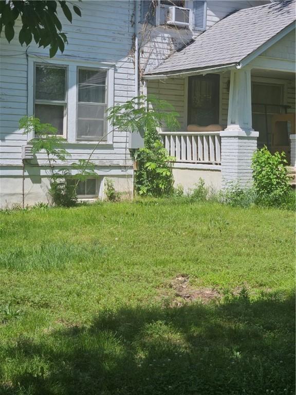 view of side of home with a lawn and a porch