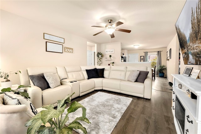 living area featuring a ceiling fan and dark wood-style flooring