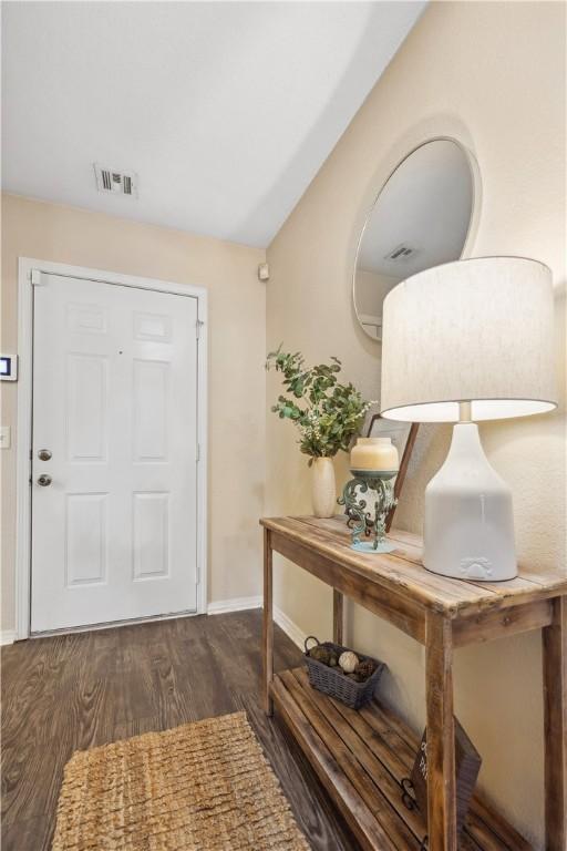 entryway featuring lofted ceiling and dark hardwood / wood-style floors